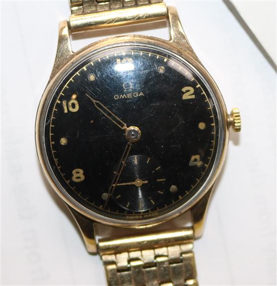 A gentlemans 1940s 9ct gold Omega wrist manual wind watch, with black Arabic dial on rolled gold bracelet.